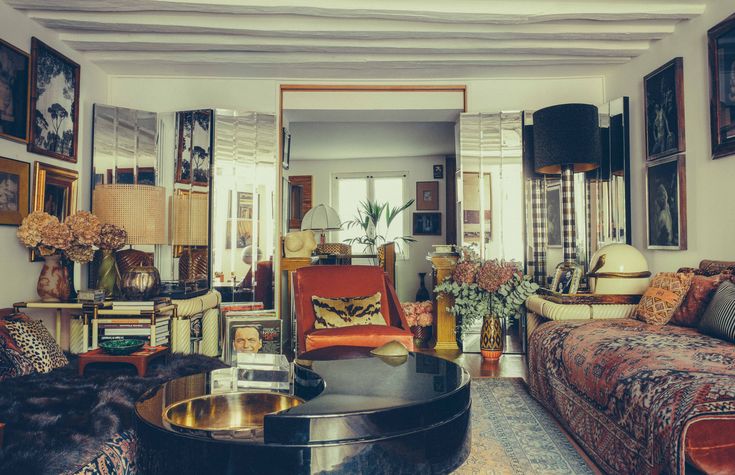 Paris apartment living room with mirrored panels, a black lacquer coffee table, patterned textiles and framed art
